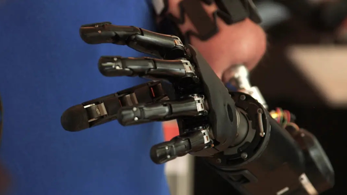 Close-up of an advanced robotic prosthetic hand with articulated fingers and exposed mechanical components.