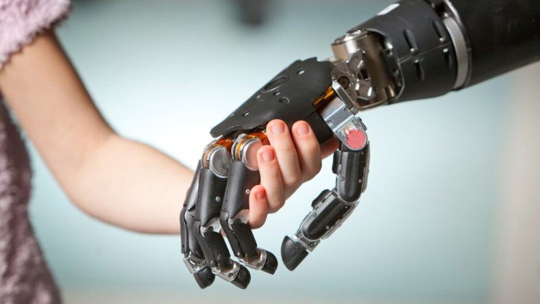 Close-up of a robotic prosthetic hand holding a child’s hand