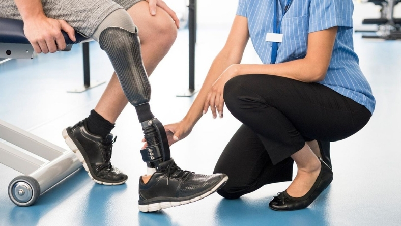 Clinician adjusts a lower-limb prosthetic during a patient fitting session